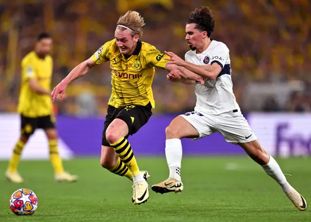 Julian Brandt of Borussia Dortmund challenges for the ball with Vitinha