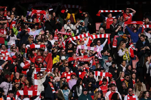 Arsenal fans hold up scarves and sing the club anthem ahead of kick off