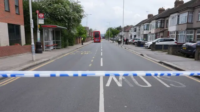 Bus in middle of road, surrounded by police tape