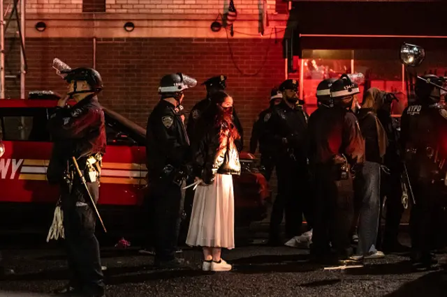 A woman stands in handcuffs after being detained by police at Columbia University