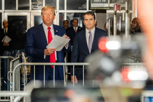 Former US President Donald Trump, with attorney Todd Blanche (R), speaks to the press as he arrives for his trial for allegedly covering up hush money payments linked to extramarital affairs, at Manhattan Criminal Court in New York City, on May 10, 2024.