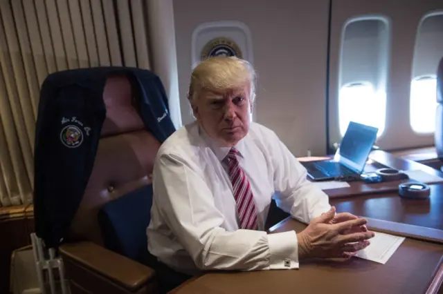 US President Donald Trump poses in his office aboard Air Force One at Andrews Air Force Base in Maryland after he returned from Philadelphia on January 26, 2017.