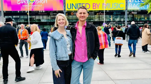 Friends Laura and Alex pose outside a stadium with the Eurovision Song Contest label