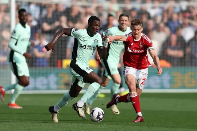 Moises Caicedo of Chelsea is challenged by Ryan Yates of Nottingham Forest during the Premier League match between Nottingham Forest and Chelsea FC