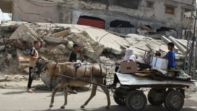 Palestinians leave Rafah on an animal-drawn cart with their a few of their belongings