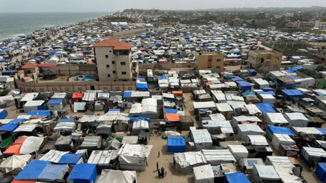 Displaced Palestinians, who fled their houses due to Israeli strikes, shelter at a tent camp in Deir Al-Balah, 11 May 2024