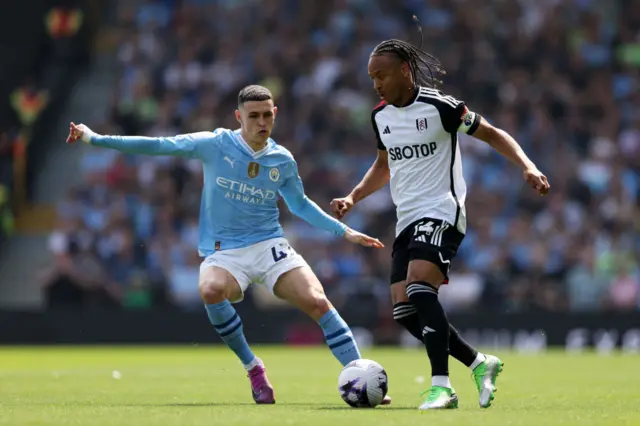 Bobby Reid of Fulham is challenged by Phil Foden of Manchester City