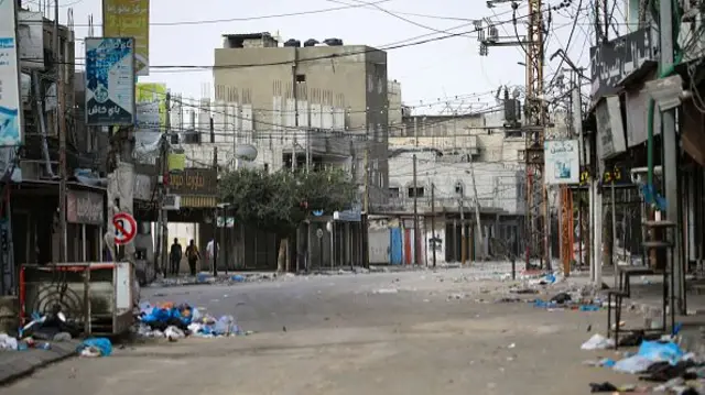 People walk along a nearly deserted street in Rafah in the southern Gaza Strip on 11 May 2024