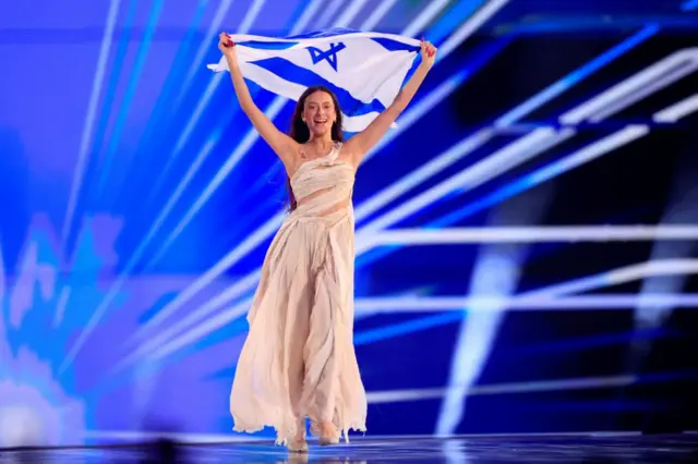 Eden Golan representing Israel with the song "Hurricane" holds an Israeli flag during dress rehearsal