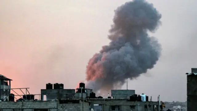 Smoke rises above buildings during an early morning Israeli strike on Rafah in the southern Gaza Strip on 11 May