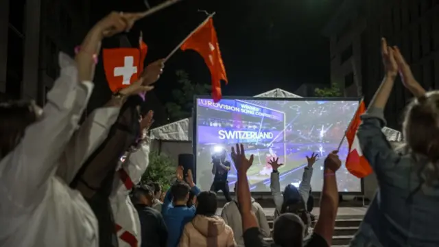 Fans on the street in Switzerland react to Nemo's win at Eurovision 2024.