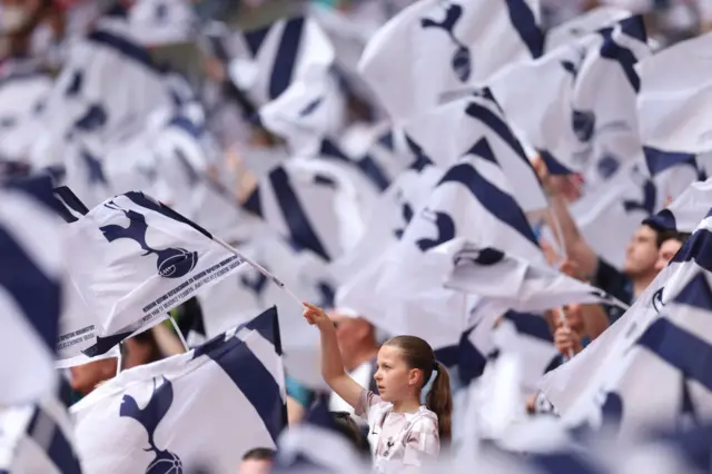 Young fan holds aloft a spurs flag