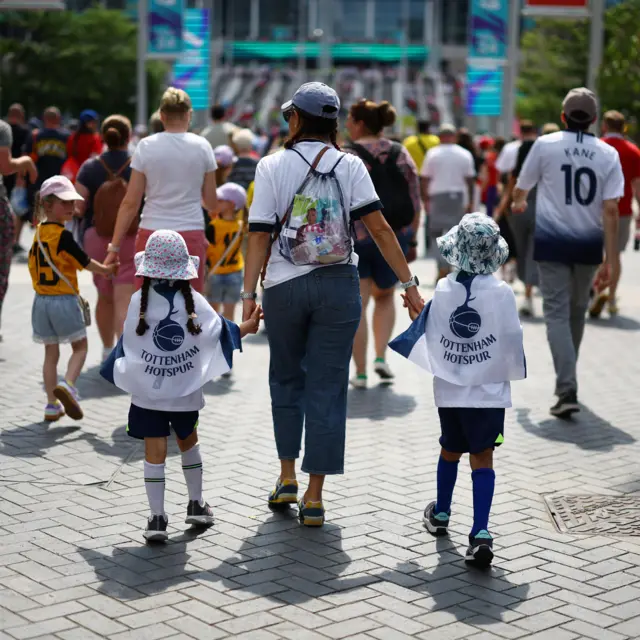 A mum with two daughters walk up Wembley way in Spurs gear