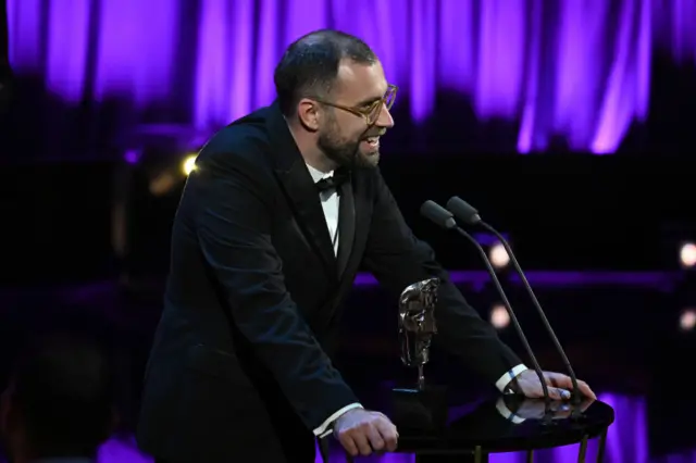 Joshua Baker accepts the current affairs award for The Shamima Begum Story (This World)