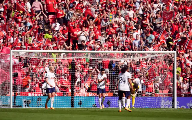 Spurs players stand stunned after the United third goal