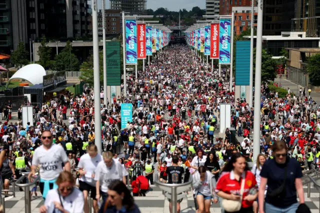 Fans walk down Wembley Way as they arrive at the stadium prior to the Adobe Women's FA Cup Final match between Manchester United and Tottenham Hotspur at Wembley Stadium