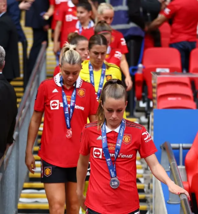 United players walk down the steps with their runners up medals