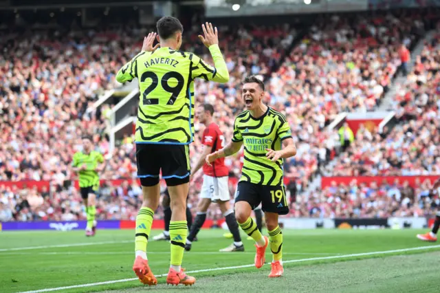 Leandro Trossard of Arsenal celebrates scoring his team's first goal with teammate Kai Havertz during the Premier League match between Manchester United and Arsenal FC