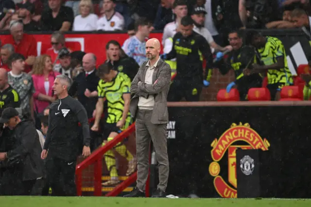 Erik ten Hag, Manager of Manchester United, leaves the field in the rain following defeat to Arsenal during the Premier League match between Manchester United and Arsenal FC