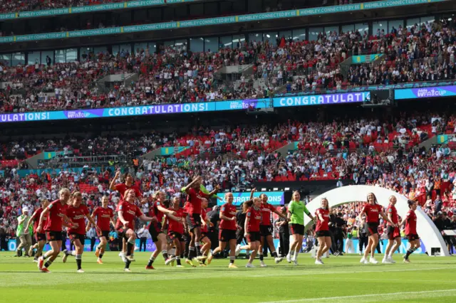 Players run to celebrate with the fans at full time