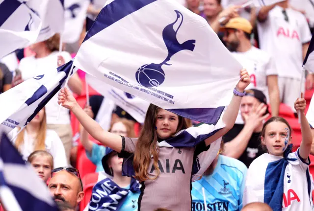 Spurs fan holds up a flag