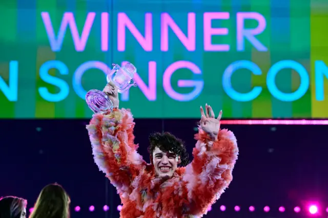 Nemo holds the iconic glass trophy after winning Eurovision 2024.