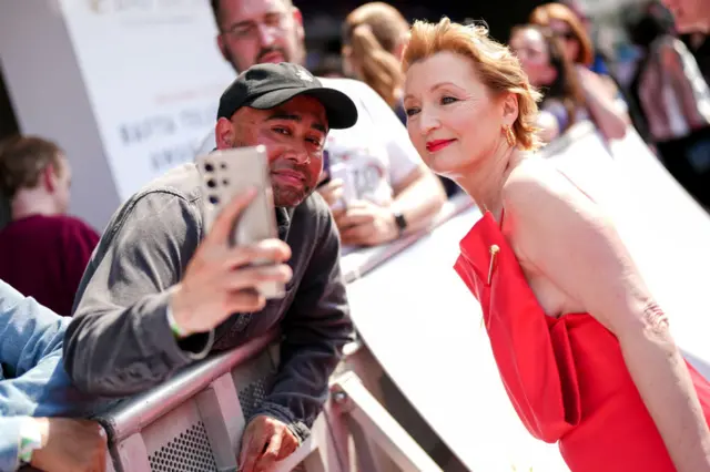 Lesley Manville of the Crown, who has been nominated for the best supporting actress, stops to take a quick selfie with a fan