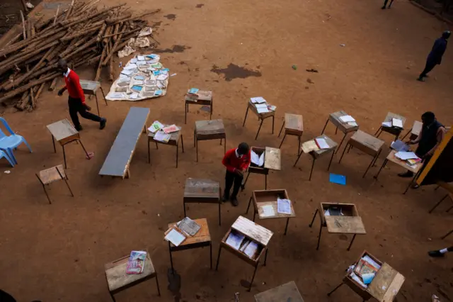 Students from Balozi secondary high school dry damp books in the sun outside their classroom that was previously affected by floods in Mathare slum in Nairobi on May 13, 2024.