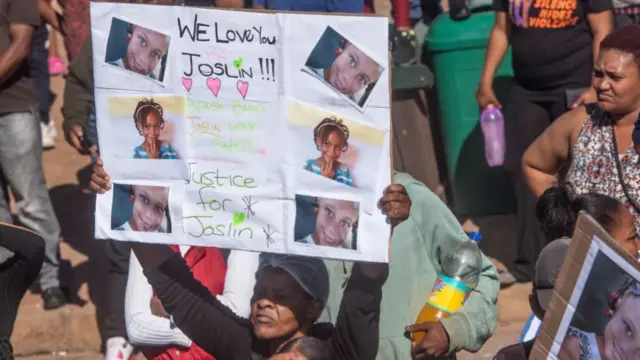 Woman holding a placard with photos of Joshlin Smith (archive shot)