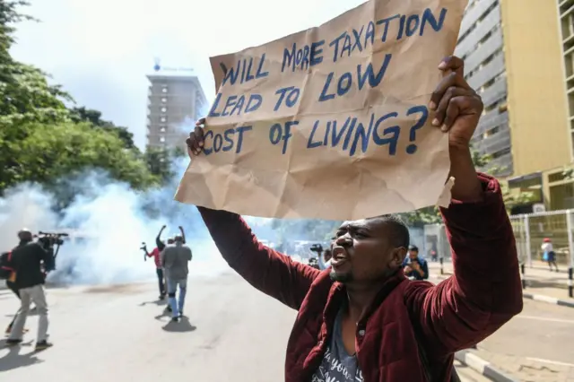 A Kenyan activist shouts amidst teargas during a protest over tax hike plans in Nairobi on June 6, 2023