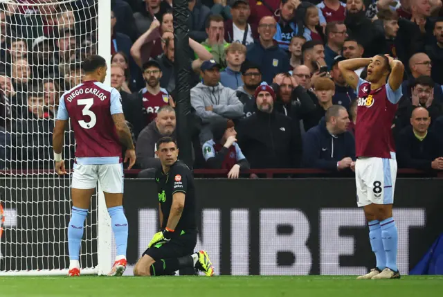 Emiliano Martinez and Youri Tielemans look dejected after Martinez scored an own goal