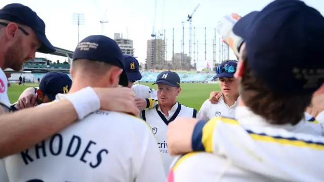 Warwickshire team huddle at the Oval