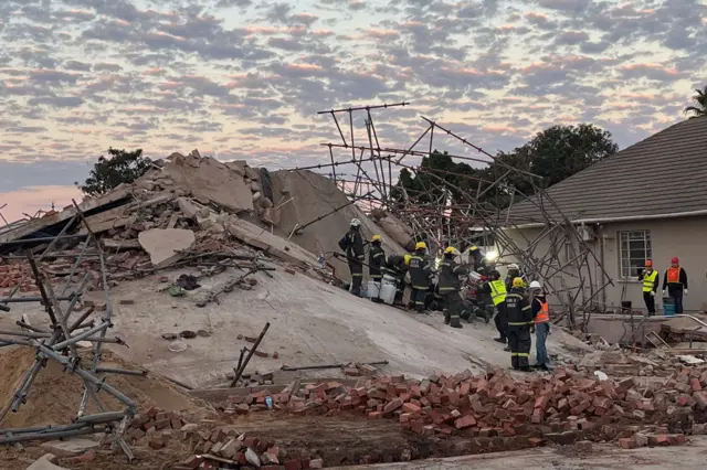 Rescue workers are seen at the scene of a collapsed building in George on May 7, 2024. The collapse of a multi-storey building under construction in the South African city of George has killed at least four people and trapped around 50 more, authorities said on May 7, 2024.