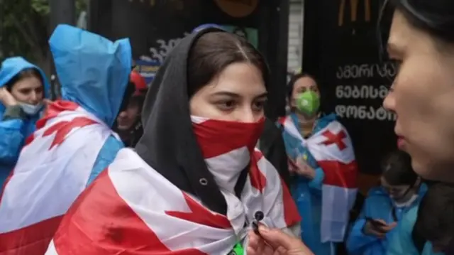 Rayhan Demytrie interviewing a protester