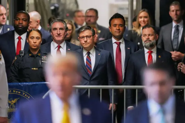 (L-R) US Representative Byron Donalds, Republican of Florida, Governor of North Dakota Doug Burgum, US Speaker of the House Mike Johnson, and former presidential candidate Vivek Ramaswamy listen as former President Donald Trump speaks to reporters