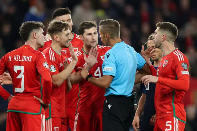 Wales players surround the referee