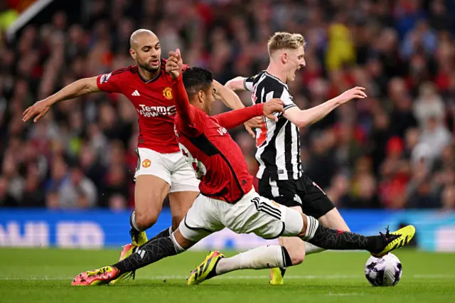 Anthony Gordon of Newcastle United is challenged by Sofyan Amrabat and Casemiro o