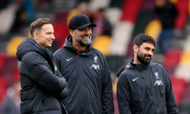 Jurgen Klopp, Manager of Liverpool, (C) speaks to his staff Pepijn Lijnders, Assistant Manager, (L) and Vitor Matos