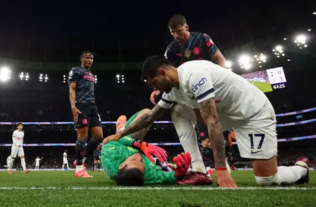 Cristian Romero of Tottenham Hotspur checks on Ederson of Manchester City