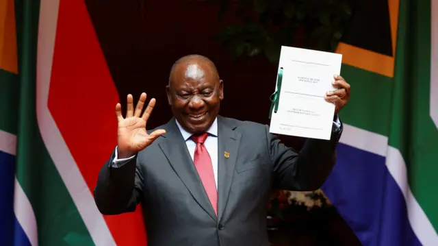 Cyril Ramaphosa holding the NHI bill