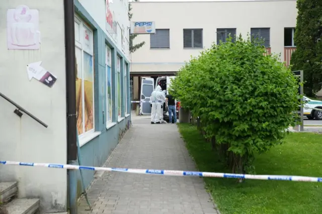 Police investigators work near the cordoned-off crime scene where Slovak Prime Minister Robert Fico was shot earlier in the day, in Handlova, Slovakia