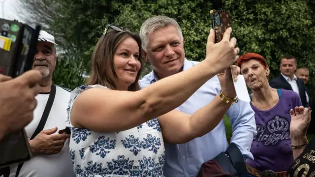 Robert Fico poses for pictures with voters.