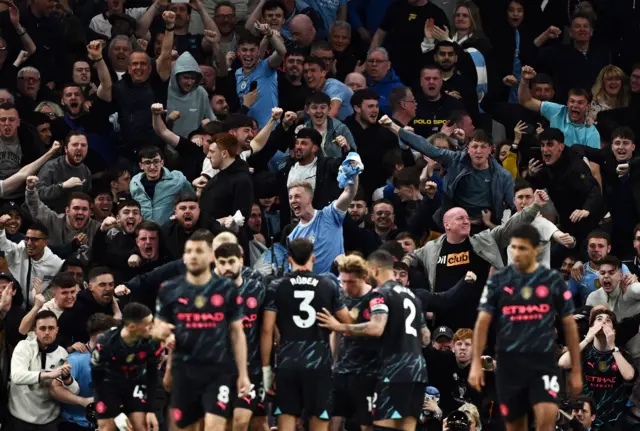 Manchester City players and fans celebrate against Tottenham