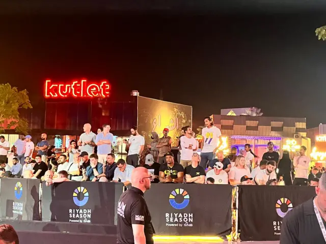 A group of people waiting to watch a news conference in Saudi Arabia