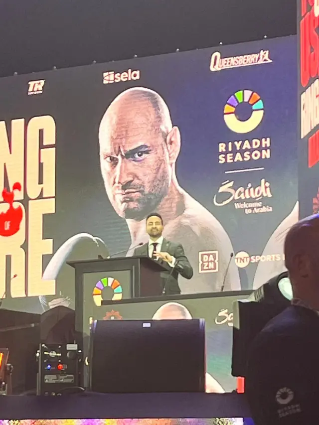 Dev Sahni on stage at a news conference