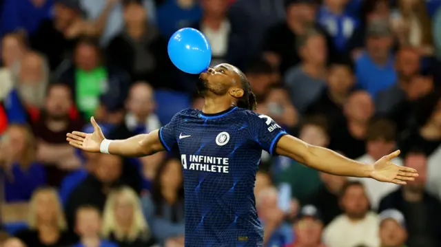 Chelsea's Christopher Nkunku celebrates scoring against Brighton by blowing up a balloon