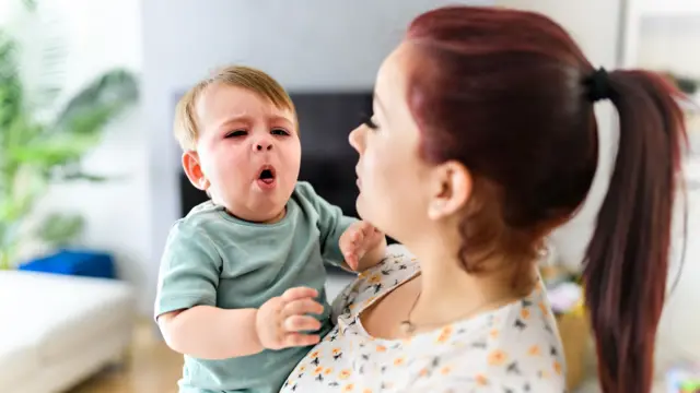 Woman holding coughing child