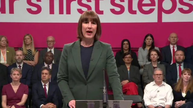 Rachel Reeves speaking in Thurrock, with Keir Starmer - complete with rolled-up sleeves - watching on with the shadow cabinet