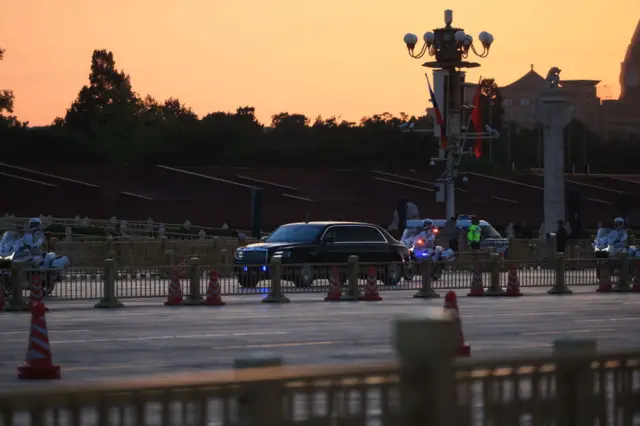 This shot shows the Russian president's car passing Tiananmen Square during sunrise.