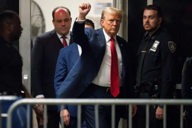 Donald Trump walking outside the courthouse with his fist in the air